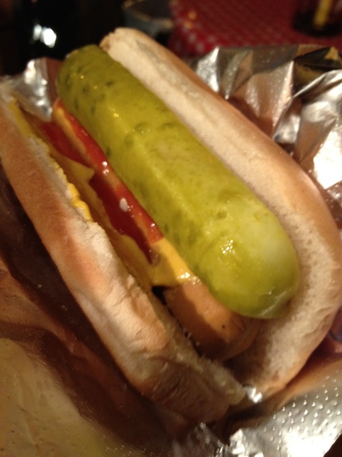 vegan hot dog and an entire slice of pickle in a bun