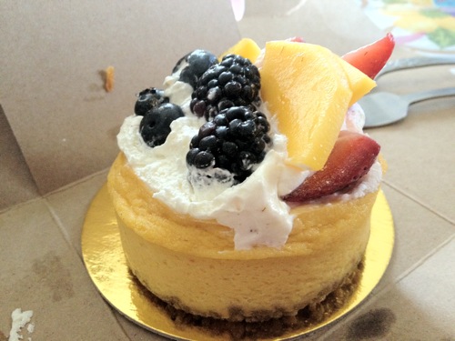 small vegan mango cheesecake topped with mango slices and blackberries